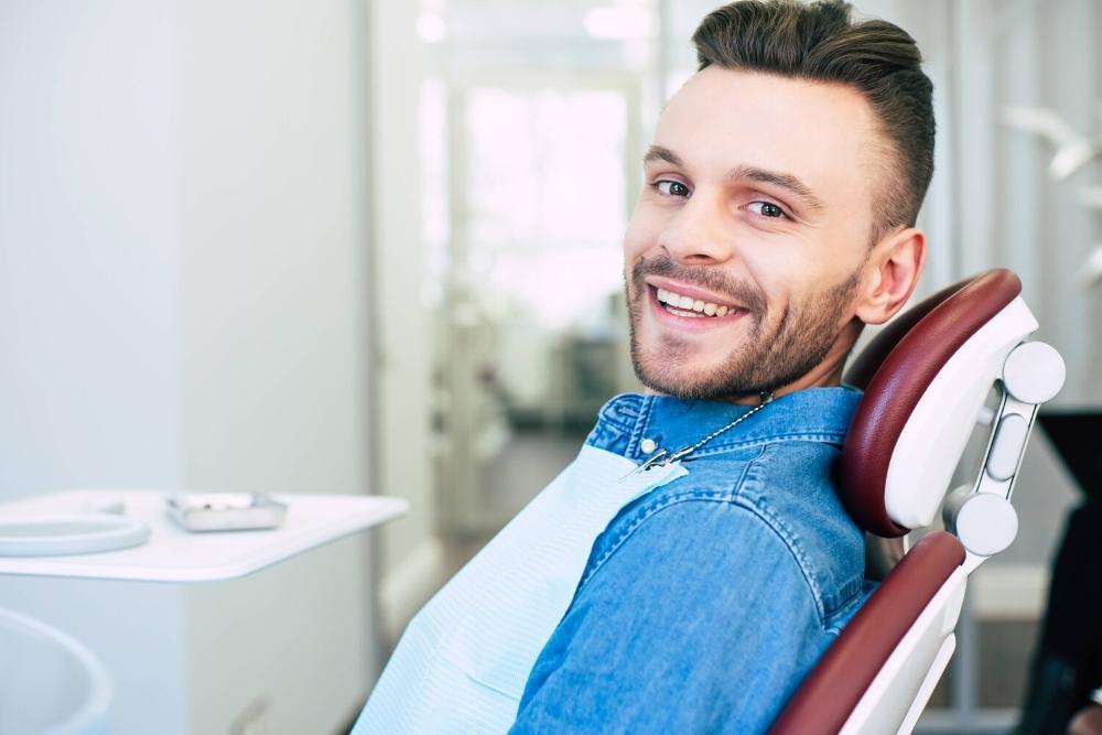man smiling in dental chair after cleaning